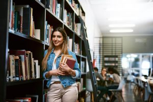 סטודנטית לומדת על עבודת סמינריון בסוציולוגיה בספריה